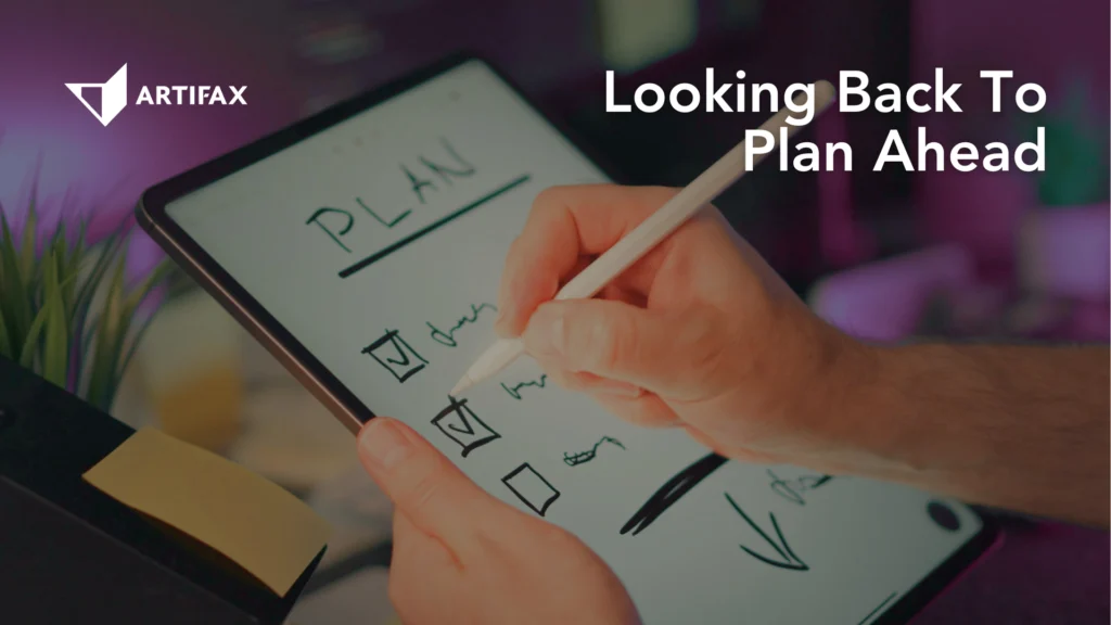 A person writes a checklist on a digital tablet using a stylus. The screen displays the word “PLAN” and several tick boxes. The background is softly lit with purple tones, and the Artifax logo appears in the upper left corner. Text reads: “Looking Back To Plan Ahead.”