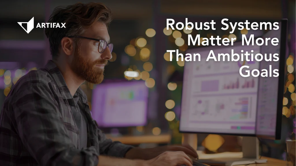 A focused professional working at a computer workstation, reviewing data and dashboards on multiple screens in a calm, structured environment.