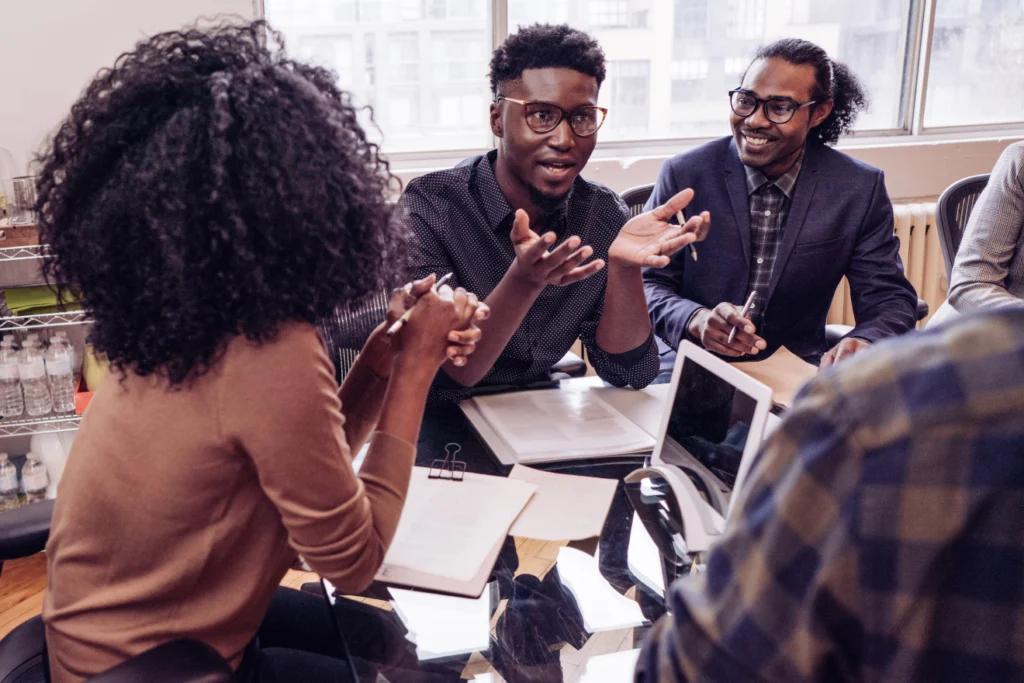Diverse team of professionals engaged in a lively brainstorming session around a table.