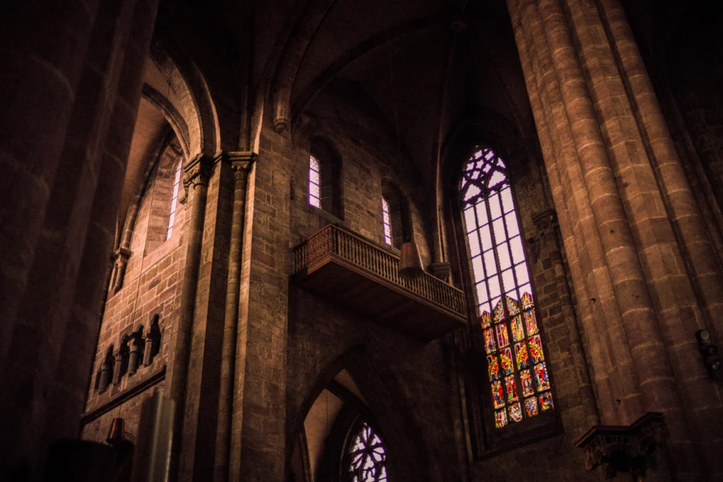 Historic cathedral interior with stained glass and gothic arches.