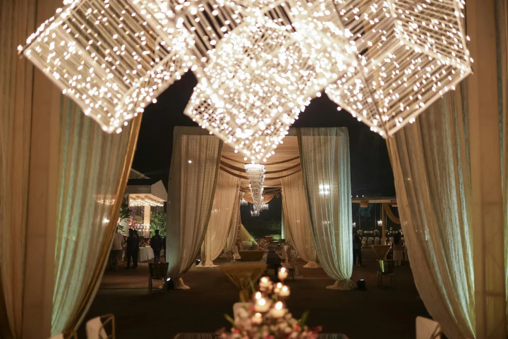 Elegant event venue decorated with lights and draped curtains at night.