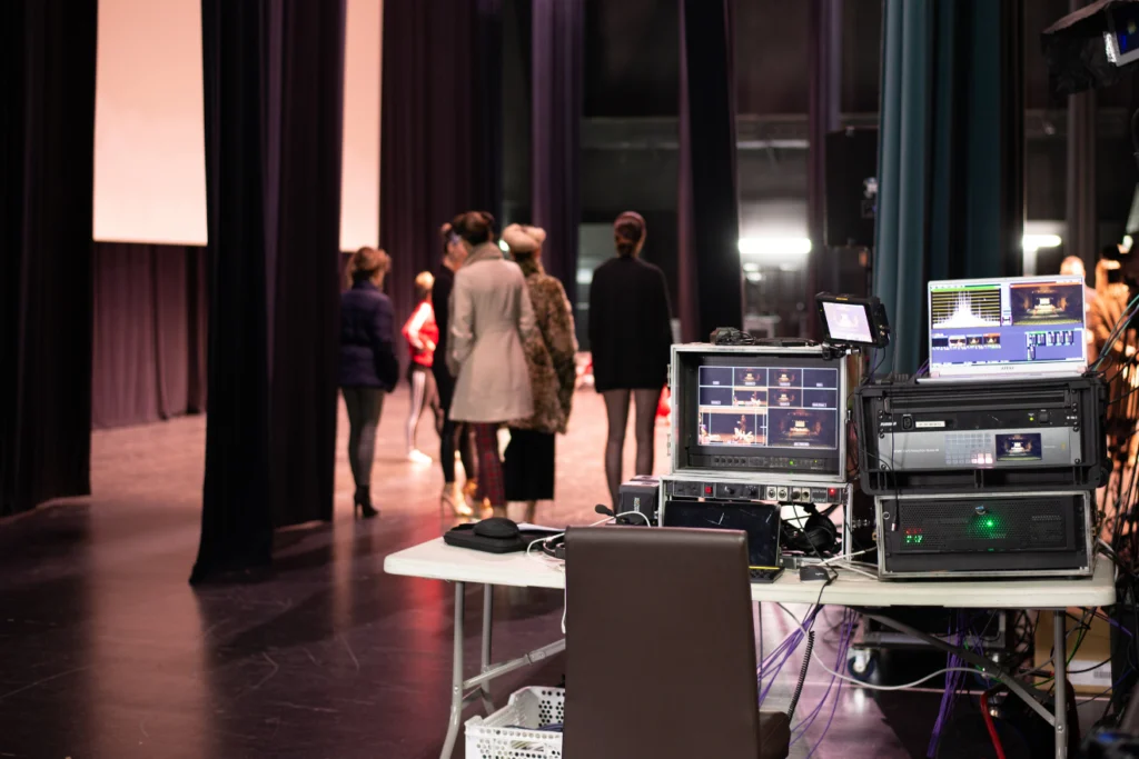Production monitors and cables set up backstage during a rehearsal.