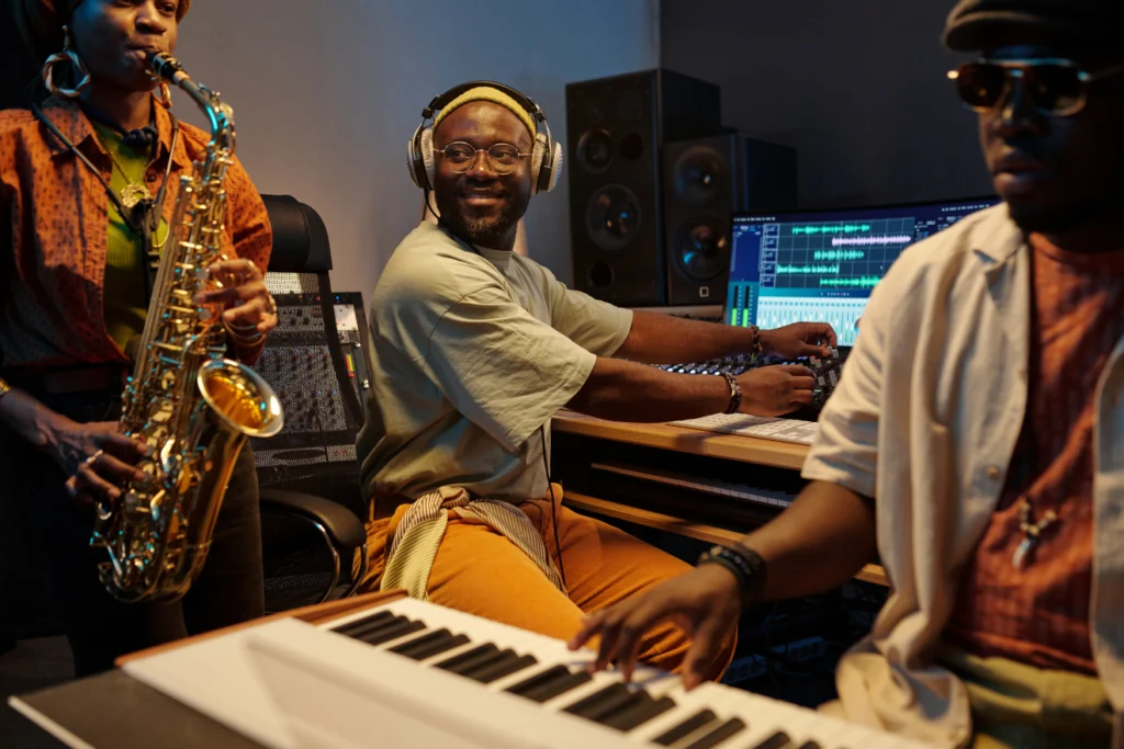 Sound engineer and musicians working together in a recording studio.