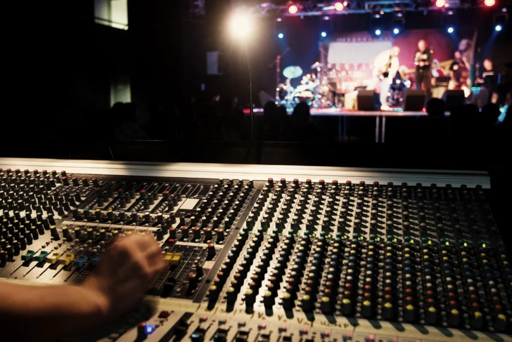 Sound technician using a mixing desk at a live music event.