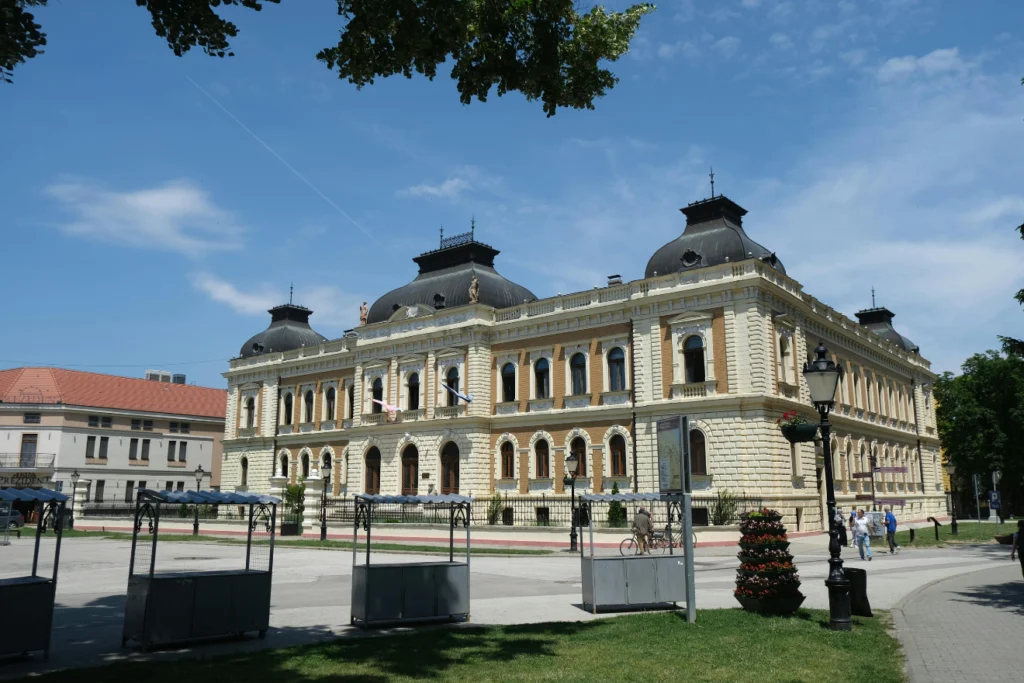 Historic civic or cultural building with ornate architecture under a blue sky.