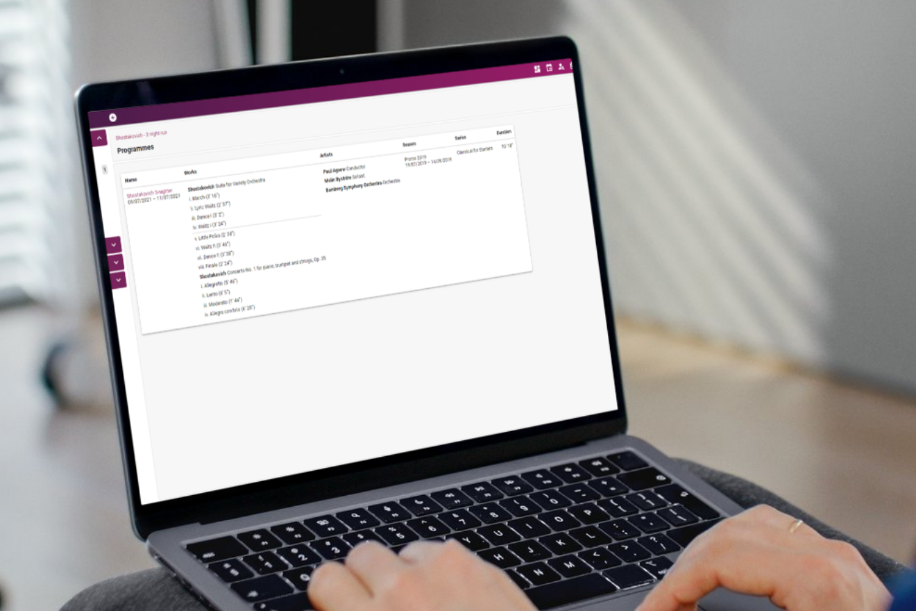 Person reviewing a programmes list on Artifax software using a laptop.
