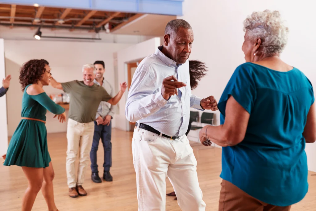 Older adults dancing joyfully at a daytime community event