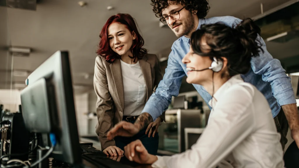 Support team collaborating at a computer workstation.