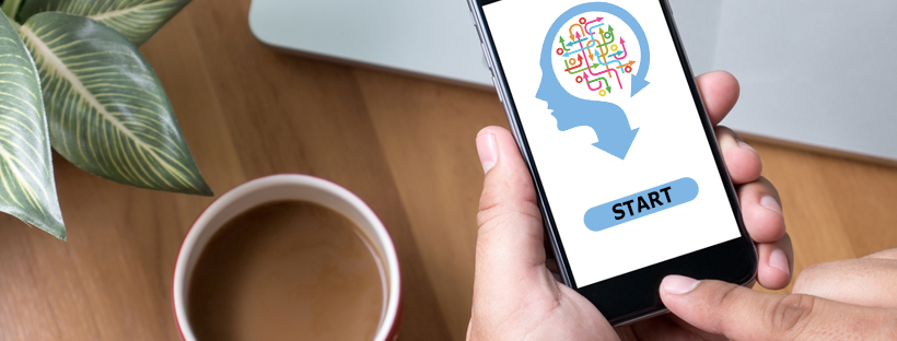 Person holding a smartphone displaying a colorful Skillfluence training graphic next to a cup of coffee.