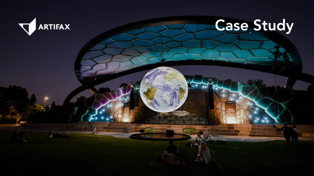 HOTA outdoor stage illuminated at night with a large glowing Earth installation and colourful architectural lighting.