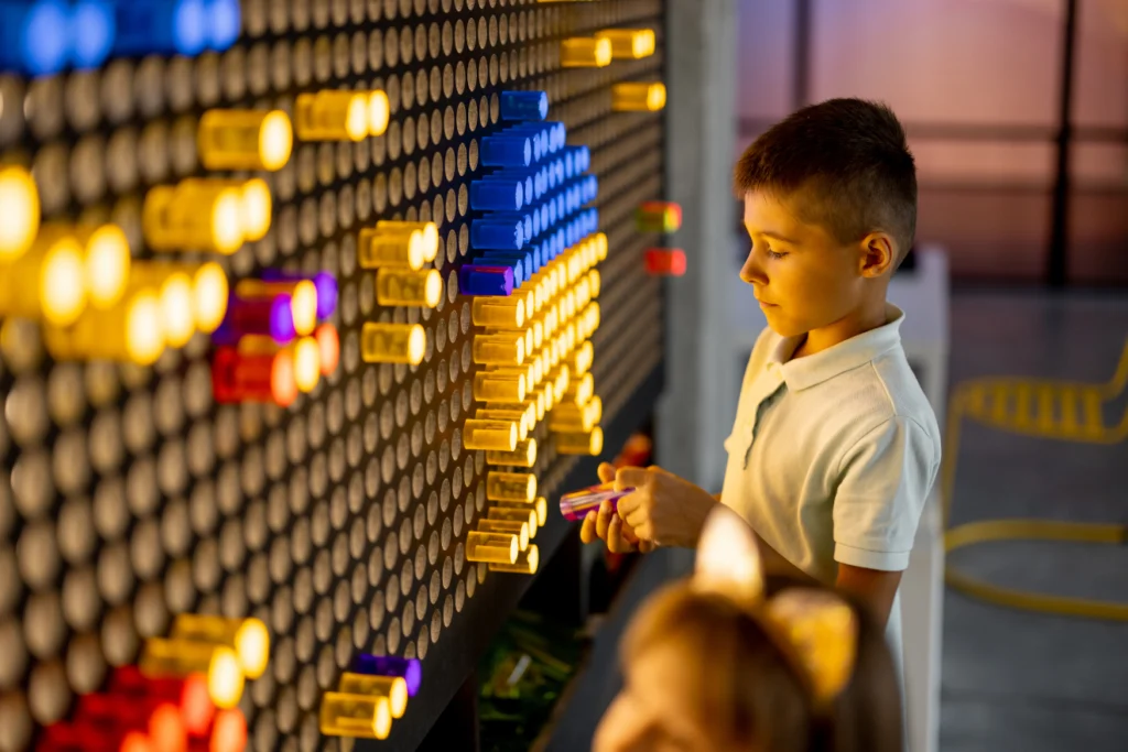 A child interacting with a colorful hands-on exhibit in a museum.