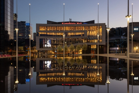 Symphony Hall Birmingham exterior at dusk reflected in the surrounding water.